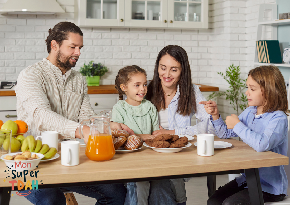 Famille réunie autour de la table au petit-déjeuner avec fruits, jus d'orange et viennoiseries